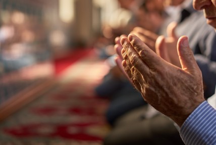 Men praying for the sake of God from inside the mosque